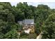 Aerial view of a two-story brick home surrounded by mature trees and lush landscaping at 105 Woodsage Way, Cary, NC 27518