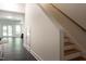Hallway with hardwood stairs, a dark tile floor, and a glimpse of a living area at 105 Woodsage Way, Cary, NC 27518