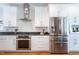 Bright kitchen featuring stainless steel appliances, granite countertops, white cabinets, and hardwood flooring at 105 Woodsage Way, Cary, NC 27518