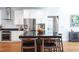 Modern kitchen with stainless steel appliances, granite countertops, white cabinets, an island, and hardwood flooring at 105 Woodsage Way, Cary, NC 27518