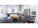 Modern kitchen island with a dark countertop, wooden stools, and ample space for food preparation at 105 Woodsage Way, Cary, NC 27518