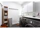 Laundry room equipped with modern Samsung washer and dryer, ample counter space, and functional storage solutions at 105 Woodsage Way, Cary, NC 27518