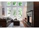 Bright living room featuring a fireplace, hardwood floors, large windows, and comfortable leather seating at 105 Woodsage Way, Cary, NC 27518