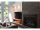 Cozy living room featuring a modern fireplace, hardwood floors, and a large window for natural light at 105 Woodsage Way, Cary, NC 27518