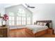 Main bedroom featuring a large window, high ceilings, and hardwood floors at 105 Woodsage Way, Cary, NC 27518