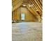 Unfinished attic space showcasing exposed wood framing and a window, offering potential for customization at 106 Viola Ln, Franklinton, NC 27525