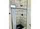 Modern tiled shower featuring sleek black fixtures, a rain shower head, and a stylish shower curtain rod at 106 Viola Ln, Franklinton, NC 27525
