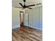 Bedroom with wood accent wall, fan, hardwood floors, with a view to other rooms at 106 Viola Ln, Franklinton, NC 27525