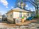 Exterior view of home showcasing the side and backyard against a bright blue sky with light clouds at 1108 Taylor Street, Durham, NC 27701