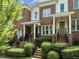 Attractive brick townhome featuring a covered entryway, manicured landscaping, and a welcoming facade at 111 Finsbury St, Durham, NC 27703