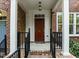Close-up of the front door featuring a dark wood finish, house number, and covered porch at 111 Finsbury St, Durham, NC 27703