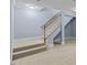 Carpeted stairs with white risers, blue wall and wood handrail at 111 Finsbury St, Durham, NC 27703