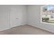 Spare bedroom features a standard double closet, a window, and neutral carpeting at 112 Edgewood Dr, Roxboro, NC 27573