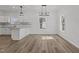 A dining area with modern light fixtures opens into a kitchen with white cabinets at 112 Edgewood Dr, Roxboro, NC 27573