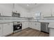 A new kitchen features stainless steel appliances, white cabinets, and granite countertops at 112 Edgewood Dr, Roxboro, NC 27573