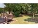 Lush backyard featuring a wooden deck, a well-maintained lawn, and mature trees for shade and privacy at 113 Kelly Ln, Clayton, NC 27520