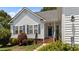 Inviting front entrance with well-kept landscaping, brick steps, and a view of the white siding home's windows at 113 Kelly Ln, Clayton, NC 27520