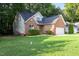 Charming brick home featuring a well-maintained lawn and attached two-car garage at 1209 Waterford Green Dr Dr, Apex, NC 27502