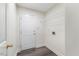 Functional laundry room with gray floors, a white door, and a wire shelf for storage at 1209 Waterford Green Dr Dr, Apex, NC 27502