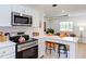 Open kitchen with stainless appliances, white cabinets, quartz counters, and eat-in breakfast bar at 1309 Hudson Ave # D14, Durham, NC 27705