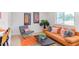 Living room with modern furnishings, bright orange couch, and natural light from a nearby window at 1309 Hudson Ave # D14, Durham, NC 27705