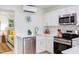 Well-lit kitchen with stainless steel appliances, white cabinets, and open view to bedroom at 1309 Hudson Ave # D5, Durham, NC 27705
