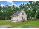 Spacious backyard with green grass, wooded area, and swing set at 132 Ironwood Ln, Clayton, NC 27520
