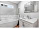 Bright bathroom featuring a soaking tub and modern vanity with chrome fixtures at 132 Ironwood Ln, Clayton, NC 27520