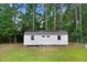 White storage shed with double doors and windows, offering practical outdoor storage space in a backyard setting at 132 Ironwood Ln, Clayton, NC 27520