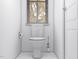 Minimalist powder room with white toilet, marble floors, and window with blindsl at 17 Runneymede Pl, Smithfield, NC 27577