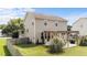A sprawling backyard view of a tan two-story home showcasing a patio and lush lawn at 1713 Mclaurin Ln, Fuquay Varina, NC 27526