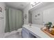 Well-lit bathroom featuring a shower with curtain, single sink vanity, and stylish decorative items at 1713 Mclaurin Ln, Fuquay Varina, NC 27526