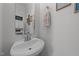 Powder room featuring a pedestal sink with silver faucet and framed decorative wall art at 1713 Mclaurin Ln, Fuquay Varina, NC 27526
