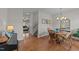 Bright dining area with hardwood floors, a chandelier, and easy access to the living room and staircase at 1713 Mclaurin Ln, Fuquay Varina, NC 27526