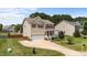 Inviting two-story home featuring a cozy front porch, lush lawn, and convenient two-car garage at 1713 Mclaurin Ln, Fuquay Varina, NC 27526