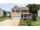 Charming two-story home with a front porch, a well-manicured lawn and a two car garage at 1713 Mclaurin Ln, Fuquay Varina, NC 27526