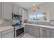 Stylish kitchen with stainless steel appliances, bright countertops, and modern gray cabinetry at 1713 Mclaurin Ln, Fuquay Varina, NC 27526