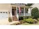 Charming porch adorned with an American flag, lush plants, and cozy seating, creating a welcoming entrance at 1713 Mclaurin Ln, Fuquay Varina, NC 27526