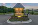 Grand Highland Estates illuminated entrance featuring stone accents, decorative flowers, and gated access at 1725 Legacy Ridge Ln, Wake Forest, NC 27587