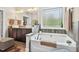 Bright bathroom showcasing a soaking tub, a large window, and stylish fixtures for a relaxing experience at 1806 Pattersons Mill Rd, Durham, NC 27703