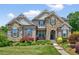 Charming two-story brick and stone home with manicured lawn and colorful landscaping at 1806 Pattersons Mill Rd, Durham, NC 27703