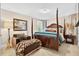 Cozy main bedroom featuring a four-poster bed, sitting area, and ample natural light at 1806 Pattersons Mill Rd, Durham, NC 27703