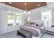 Serene main bedroom offers a tray ceiling, neutral tones, plush bedding, and abundant natural light at 189 Churchill Way, Clayton, NC 27520