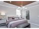 Cozy main bedroom with a large bed, elegant lighting, and access to a luxurious en-suite bathroom at 189 Churchill Way, Clayton, NC 27520