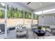 Screened patio with comfortable seating, outdoor fireplace, and view of landscaped backyard at 189 Churchill Way, Clayton, NC 27520