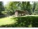 Backyard with a brick house exterior, grassy lawn, and partial fencing offering a private outdoor space at 1964 Wellington Rd, Burlington, NC 27217