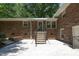 Brick home's backyard featuring a staircase leading to a door, offering easy access and outdoor charm at 1964 Wellington Rd, Burlington, NC 27217