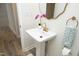 Close-up of a bathroom pedestal sink with gold faucet and a decorative mirror at 1964 Wellington Rd, Burlington, NC 27217