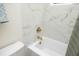 Clean white bathtub with marble tile surround and gold-toned fixtures, bathed in natural light at 1964 Wellington Rd, Burlington, NC 27217
