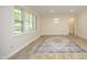 Sun-drenched living room with refinished floors, neutral walls, and large windows showcasing the front yard at 1964 Wellington Rd, Burlington, NC 27217